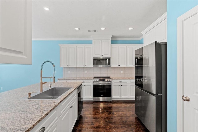 1717 Ethan Way, Hephzibah, GA 30815 - kitchen with stainless steel appliances, white cabinets, dark wood finished floors, crown molding, and tasteful backsplash