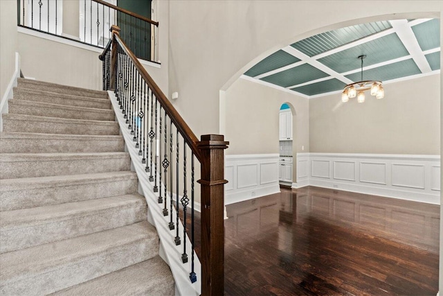 1717 Ethan Way, Hephzibah, GA 30815 - stairs featuring wood finished floors, arched walkways, coffered ceiling, a wainscoted wall, and a chandelier