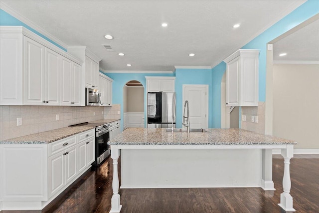 1717 Ethan Way, Hephzibah, GA 30815 - kitchen featuring appliances with stainless steel finishes, crown molding, light stone counters, dark wood-style flooring, and arched walkways