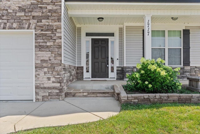 1717 Ethan Way, Hephzibah, GA 30815 - entrance to property featuring stone siding, an attached garage, and covered porch