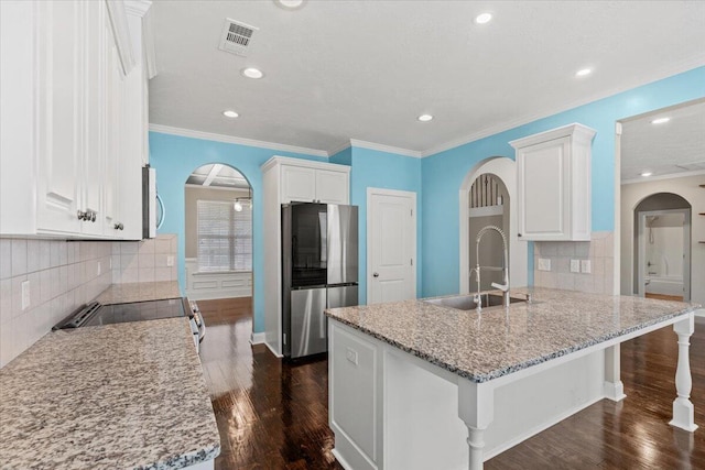 1717 Ethan Way, Hephzibah, GA 30815 - kitchen with appliances with stainless steel finishes, arched walkways, a peninsula, white cabinets, and backsplash