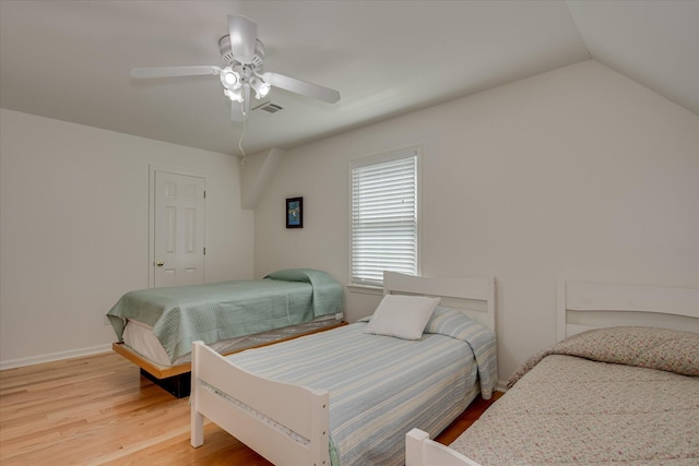 bedroom featuring lofted ceiling, visible vents, a ceiling fan, and light wood-style flooring