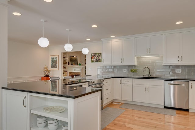 kitchen featuring open shelves, white cabinets, a sink, appliances with stainless steel finishes, and dark countertops