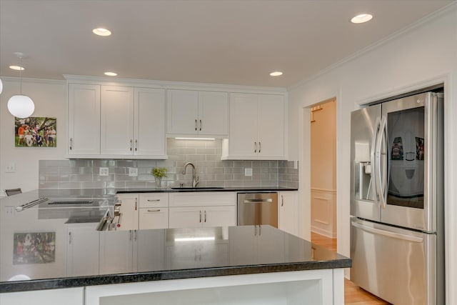 kitchen featuring dark countertops, a sink, white cabinets, and stainless steel appliances