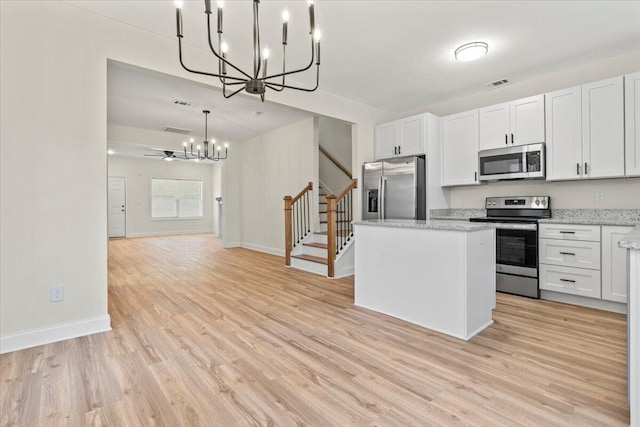 1227 Miller St, Augusta, GA 30901 - kitchen featuring appliances with stainless steel finishes, a chandelier, light wood-type flooring, and a center island
