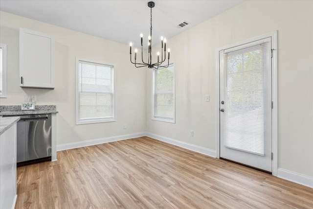 1227 Miller St, Augusta, GA 30901 - kitchen featuring dishwasher, a chandelier, light wood-style floors, light stone counters, and white cabinetry