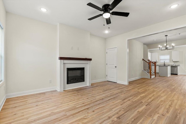 1227 Miller St, Augusta, GA 30901 - unfurnished living room with light wood-type flooring, a glass covered fireplace, a chandelier, baseboards, and recessed lighting