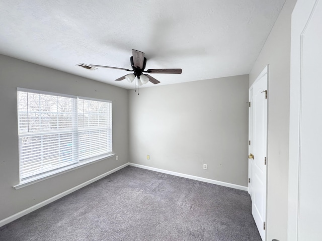 carpeted empty room featuring visible vents, baseboards, a textured ceiling, and a ceiling fan