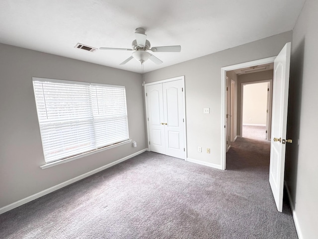 unfurnished bedroom featuring carpet, baseboards, visible vents, ceiling fan, and a closet