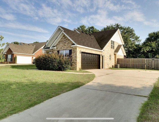 view of front facade with a front lawn, driveway, stone siding, fence, and a garage