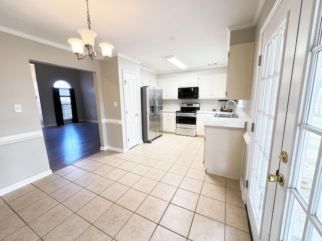 kitchen with light countertops, ornamental molding, light tile patterned floors, appliances with stainless steel finishes, and a sink