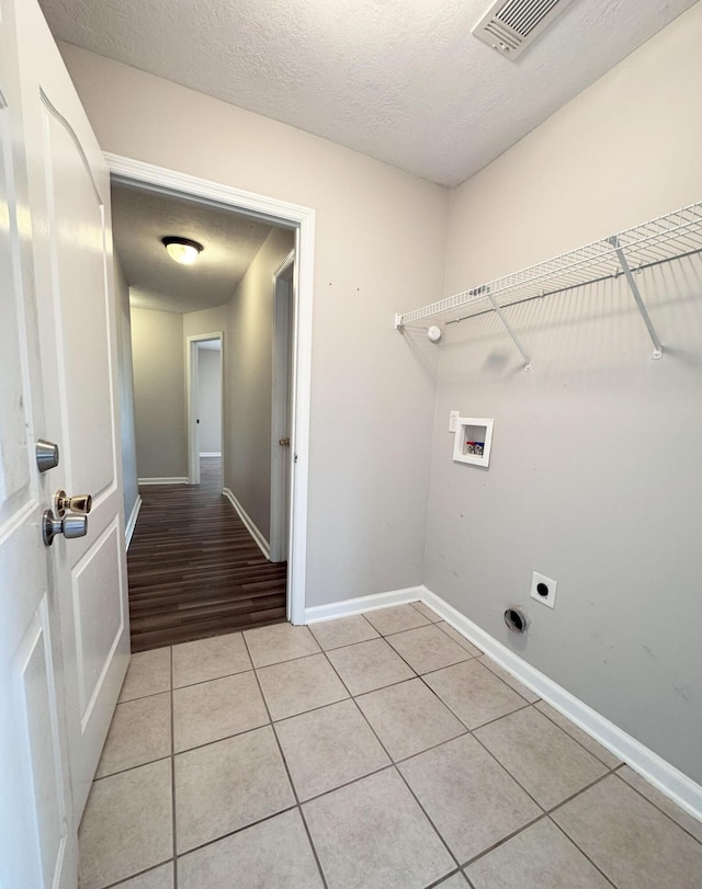 laundry room featuring hookup for a washing machine, light tile patterned floors, visible vents, laundry area, and a textured ceiling