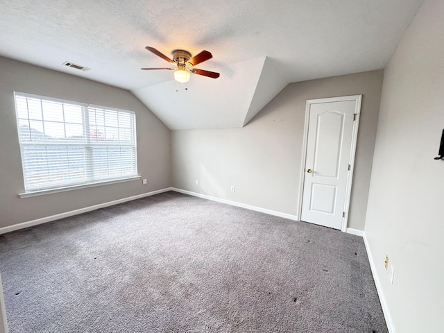 additional living space with lofted ceiling, visible vents, carpet floors, and a textured ceiling