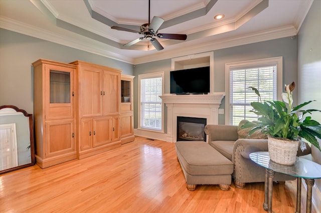 3953 Bolton St, Augusta, GA 30909 - living room featuring light wood-style flooring, ceiling fan, a glass covered fireplace, ornamental molding, and a raised ceiling