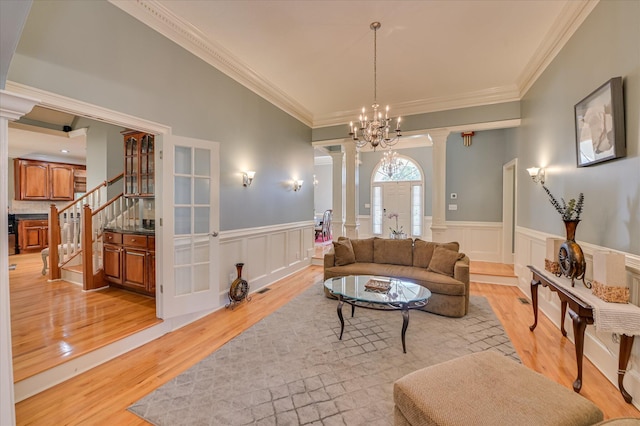 3953 Bolton St, Augusta, GA 30909 - living area with ornate columns, light wood-style floors, crown molding, stairs, and wainscoting