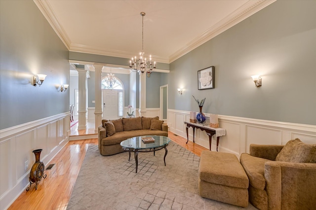 3953 Bolton St, Augusta, GA 30909 - living area with a decorative wall, a chandelier, ornate columns, a wainscoted wall, and wood finished floors