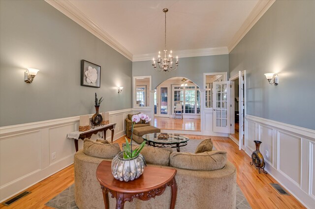 3953 Bolton St, Augusta, GA 30909 - living room with arched walkways, crown molding, a decorative wall, light wood finished floors, and a wainscoted wall
