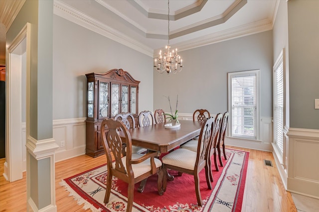 3953 Bolton St, Augusta, GA 30909 - dining area with light wood-style flooring, a chandelier, wainscoting, a decorative wall, and crown molding