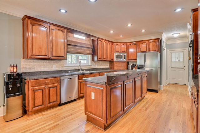 3953 Bolton St, Augusta, GA 30909 - kitchen with stainless steel appliances, ornamental molding, a kitchen island, light wood-style floors, and brown cabinets