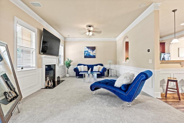 556 Ernestine Fls, Grovetown, GA 30813 - living area with a ceiling fan, a decorative wall, a fireplace with flush hearth, ornamental molding, and wainscoting