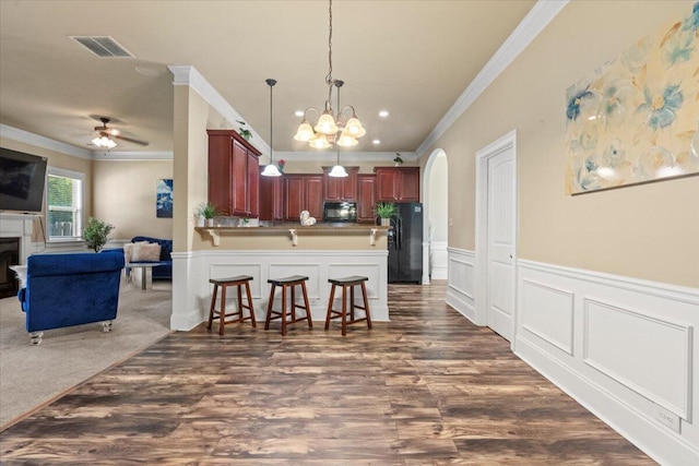 556 Ernestine Fls, Grovetown, GA 30813 - kitchen with black appliances, open floor plan, ornamental molding, a breakfast bar, and arched walkways