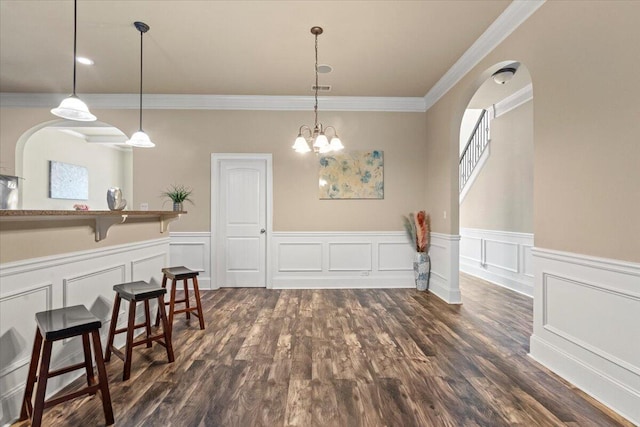 556 Ernestine Fls, Grovetown, GA 30813 - dining area featuring ornamental molding, wainscoting, dark wood finished floors, arched walkways, and a decorative wall