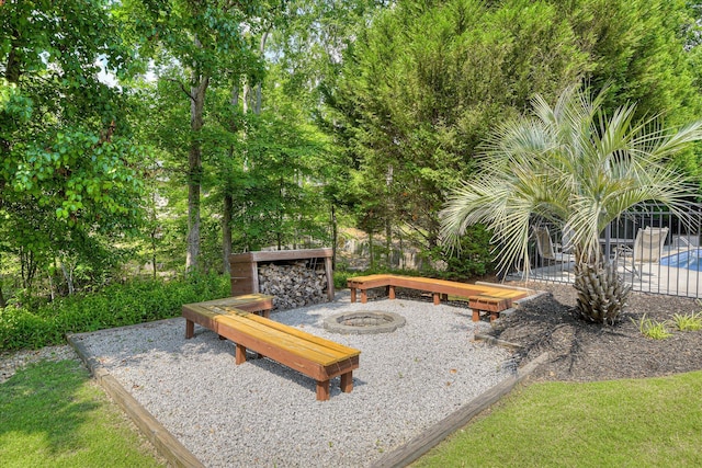 surrounding community featuring an outdoor fire pit and fence