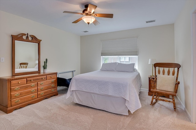 bedroom with ceiling fan, visible vents, light carpet, and baseboards