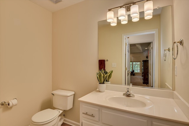 bathroom with vanity, baseboards, and toilet
