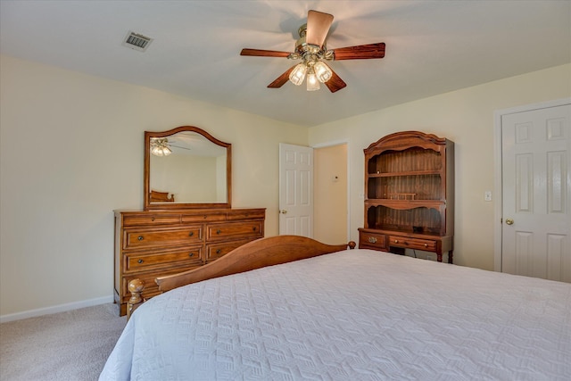 carpeted bedroom with visible vents, a ceiling fan, and baseboards
