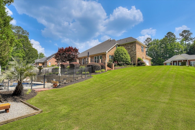 view of yard with a fenced in pool, a garage, and fence