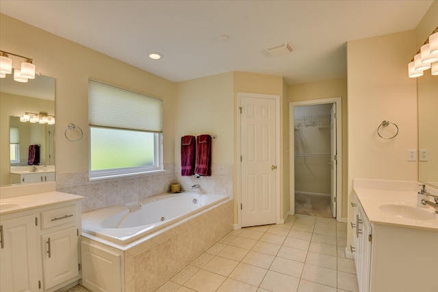 bathroom with a jetted tub, visible vents, two vanities, a sink, and tile patterned floors