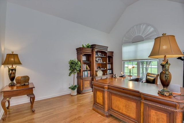 home office featuring baseboards, light wood-style flooring, and lofted ceiling