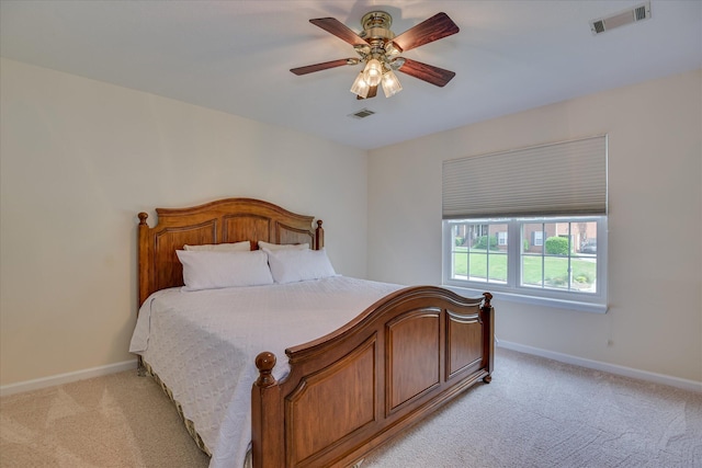 bedroom featuring baseboards, light carpet, a ceiling fan, and visible vents