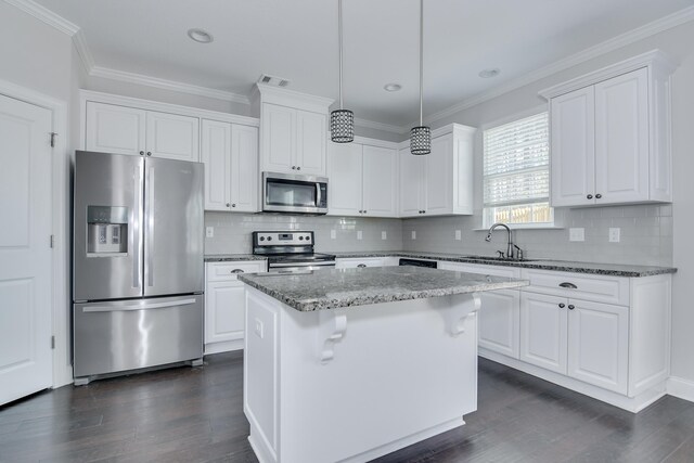 141 Caroleton Dr, Grovetown, GA 30813 - kitchen featuring stainless steel appliances, dark wood-style floors, ornamental molding, a kitchen island, and white cabinetry