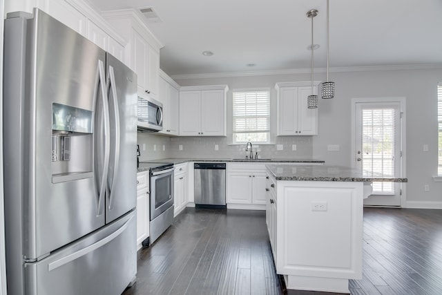 141 Caroleton Dr, Grovetown, GA 30813 - kitchen featuring appliances with stainless steel finishes, a kitchen island, white cabinetry, crown molding, and dark wood-style floors