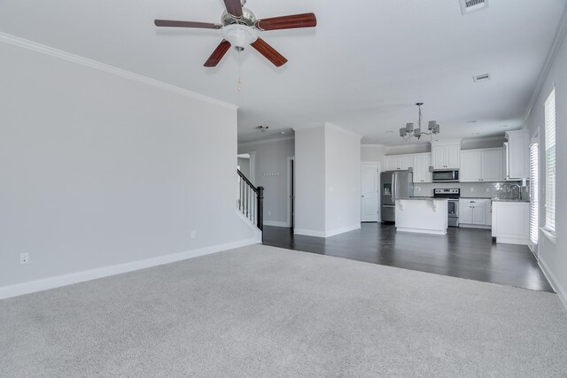 141 Caroleton Dr, Grovetown, GA 30813 - unfurnished living room featuring dark colored carpet, a chandelier, ornamental molding, ceiling fan, and stairs