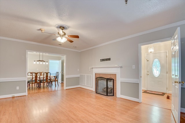 280 W Forrest St, Harlem, GA 30814 - living area featuring a ceiling fan, light wood-style floors, a tile fireplace, ornamental molding, and a textured ceiling