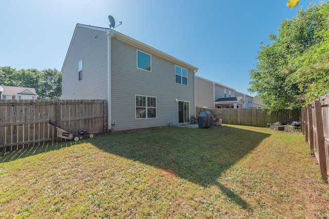back of property featuring a lawn and a fenced backyard