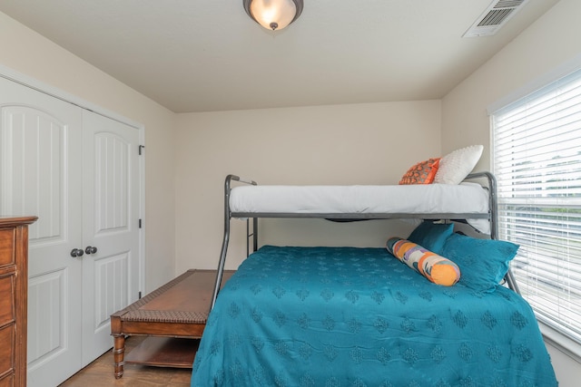 bedroom featuring visible vents, wood finished floors, and a closet