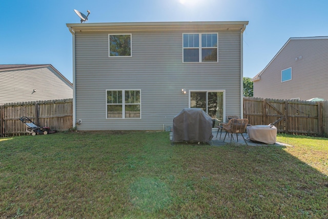 back of house with a patio, a fenced backyard, and a yard