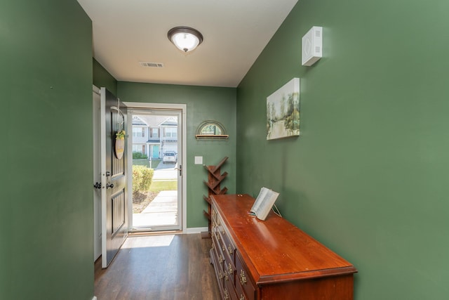 doorway featuring baseboards, visible vents, and dark wood-type flooring