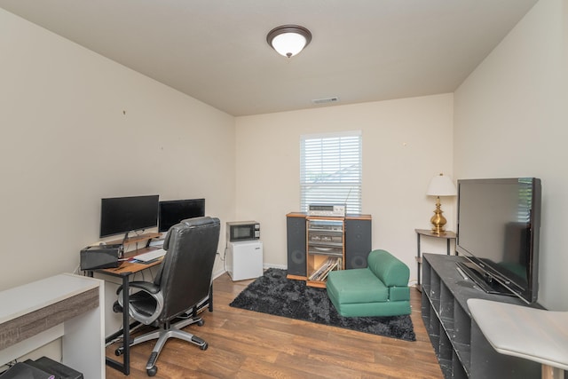 office featuring baseboards, wood finished floors, and visible vents