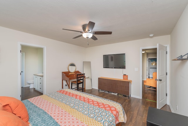 bedroom featuring baseboards, a ceiling fan, dark wood-style floors, and ensuite bath