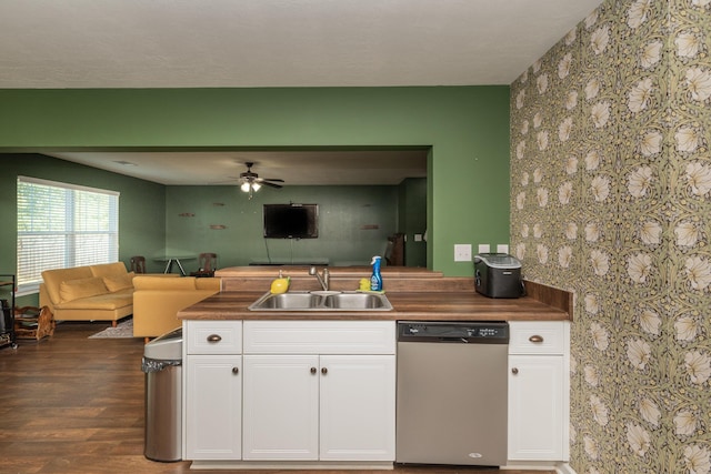 kitchen featuring stainless steel dishwasher, a sink, white cabinets, and open floor plan
