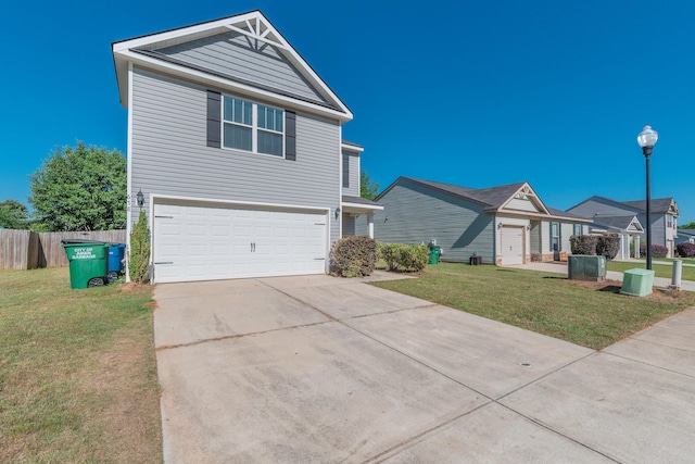 traditional home featuring fence, an attached garage, driveway, and a front lawn