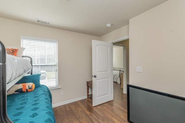 bedroom featuring baseboards, dark wood finished floors, and visible vents