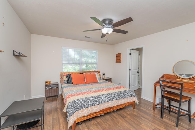 bedroom with baseboards, ceiling fan, wood finished floors, and visible vents