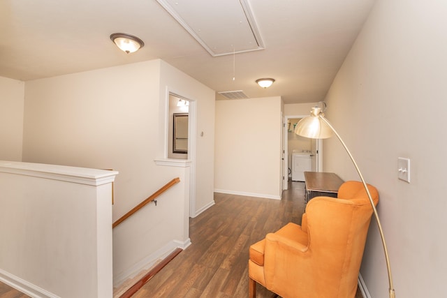sitting room featuring wood finished floors, baseboards, attic access, washer / clothes dryer, and an upstairs landing