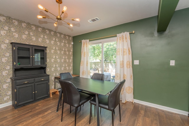 dining area featuring dark wood-style flooring, a chandelier, baseboards, wallpapered walls, and visible vents